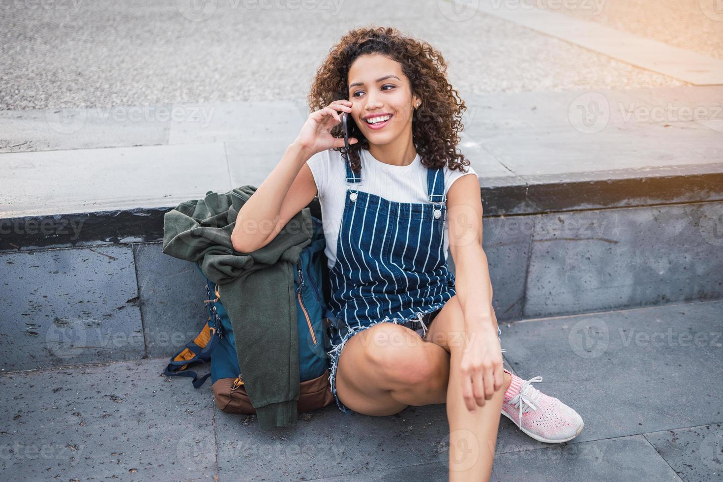 happy latina girl talking on a smartphone photo