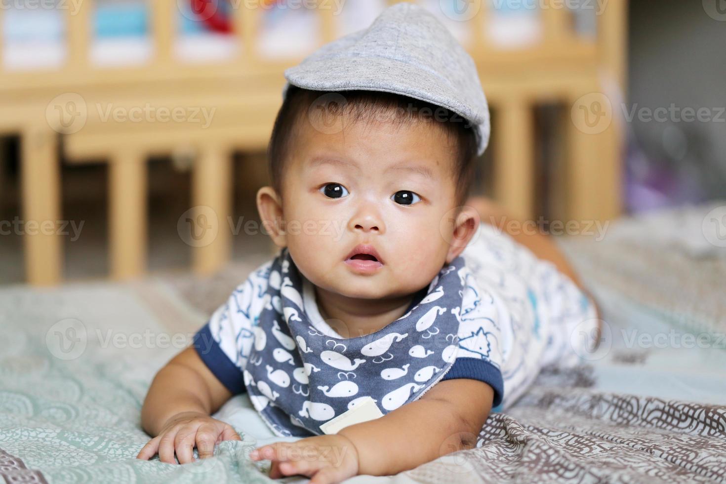 Asian baby lying on bed. photo