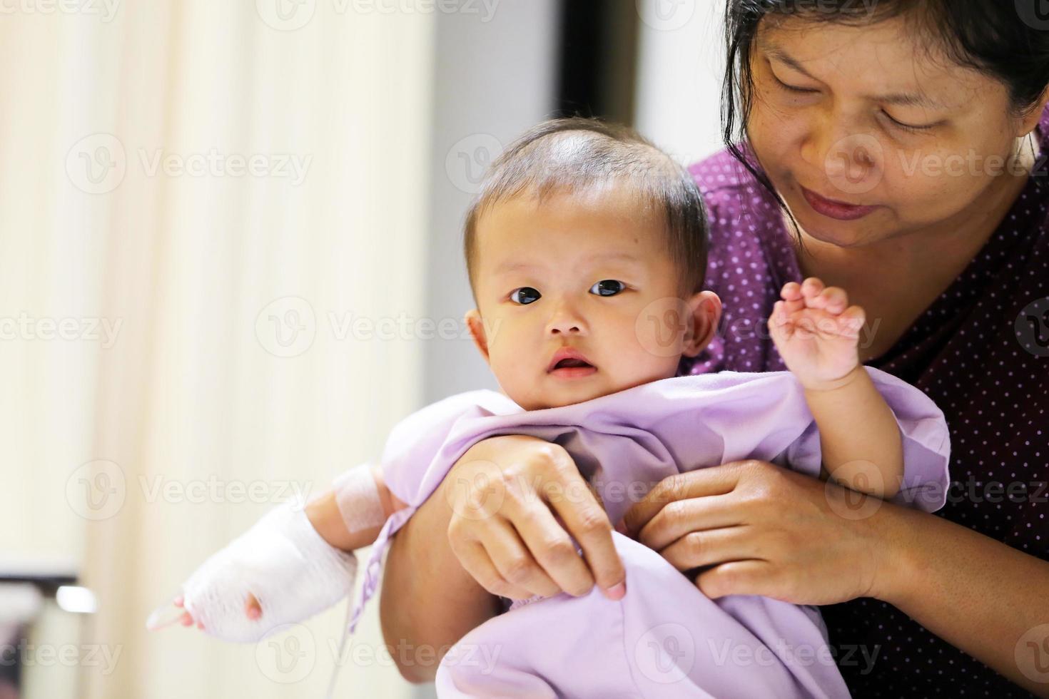 Asian baby in hospital with mother. Sick child with mother in hospital photo