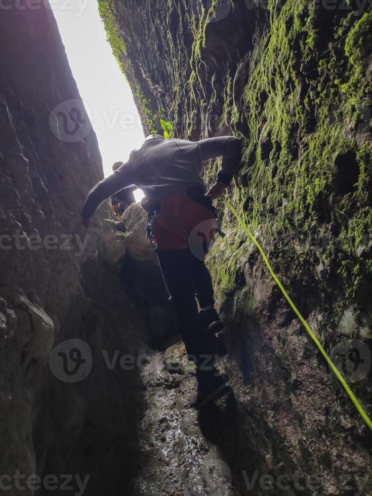 Young man descending by rappelling photo