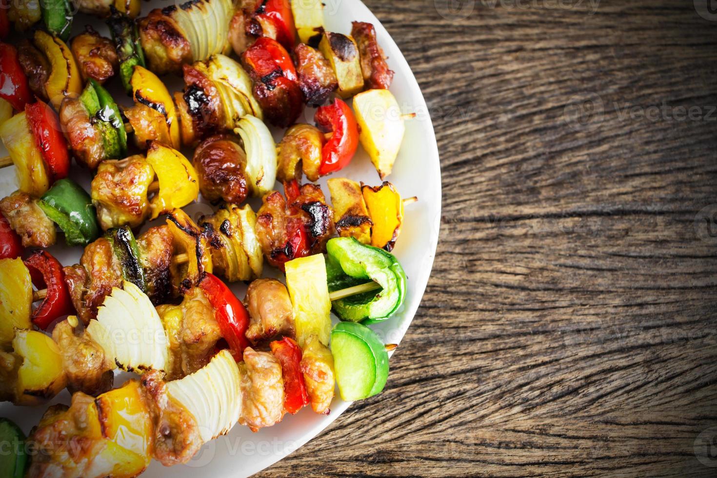 Healthy barbecued lean cubed pork kebabs on old wood table photo