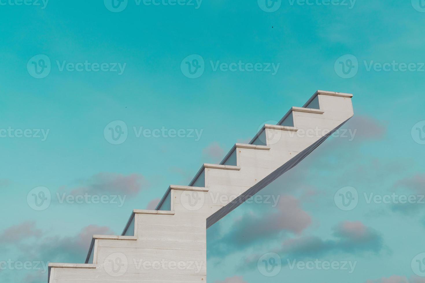 side view of white wooden stairs with fantasy blue sky and clouds, in the background photo