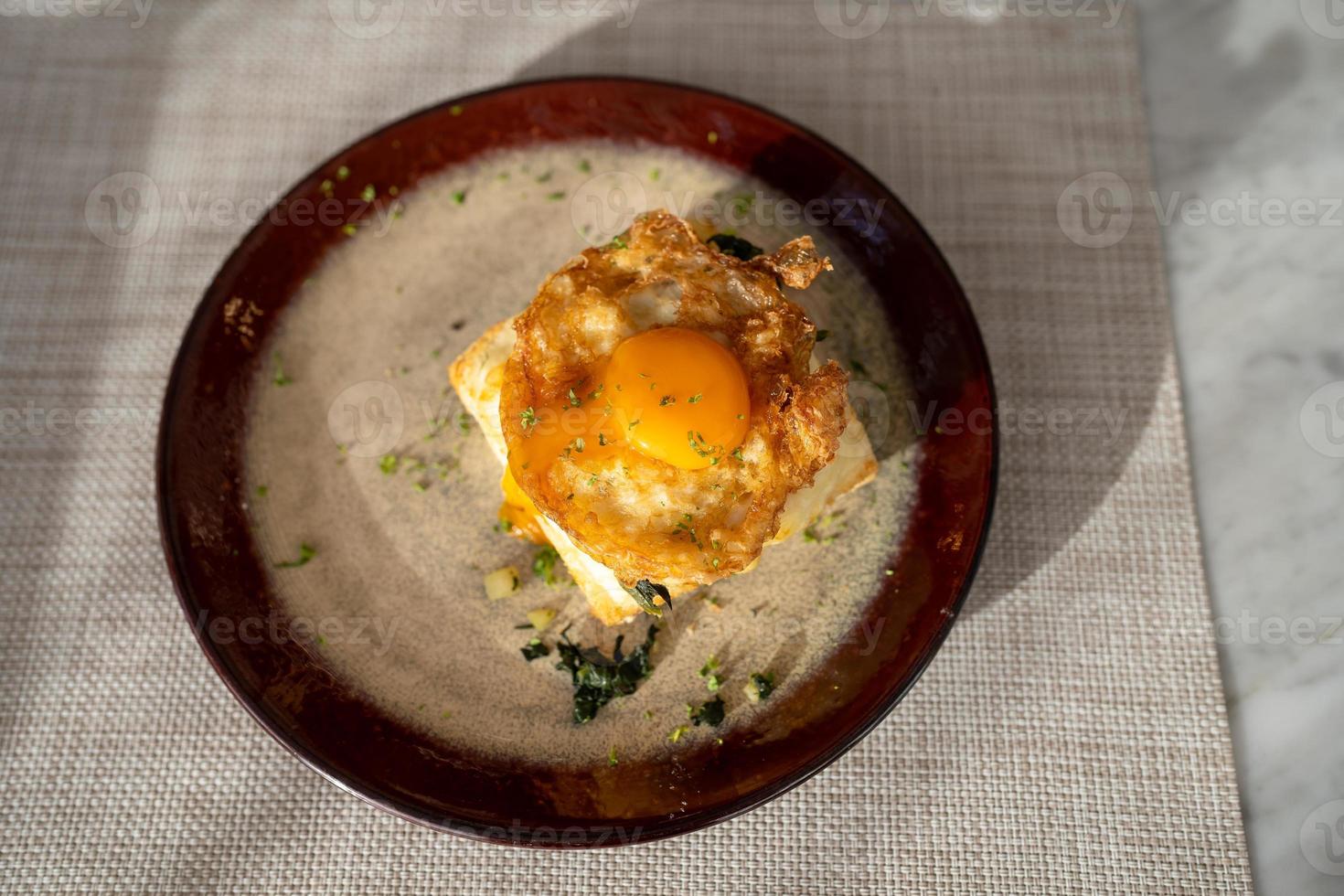 top view of fried egg top on sandwich on dish for breakfast on table photo