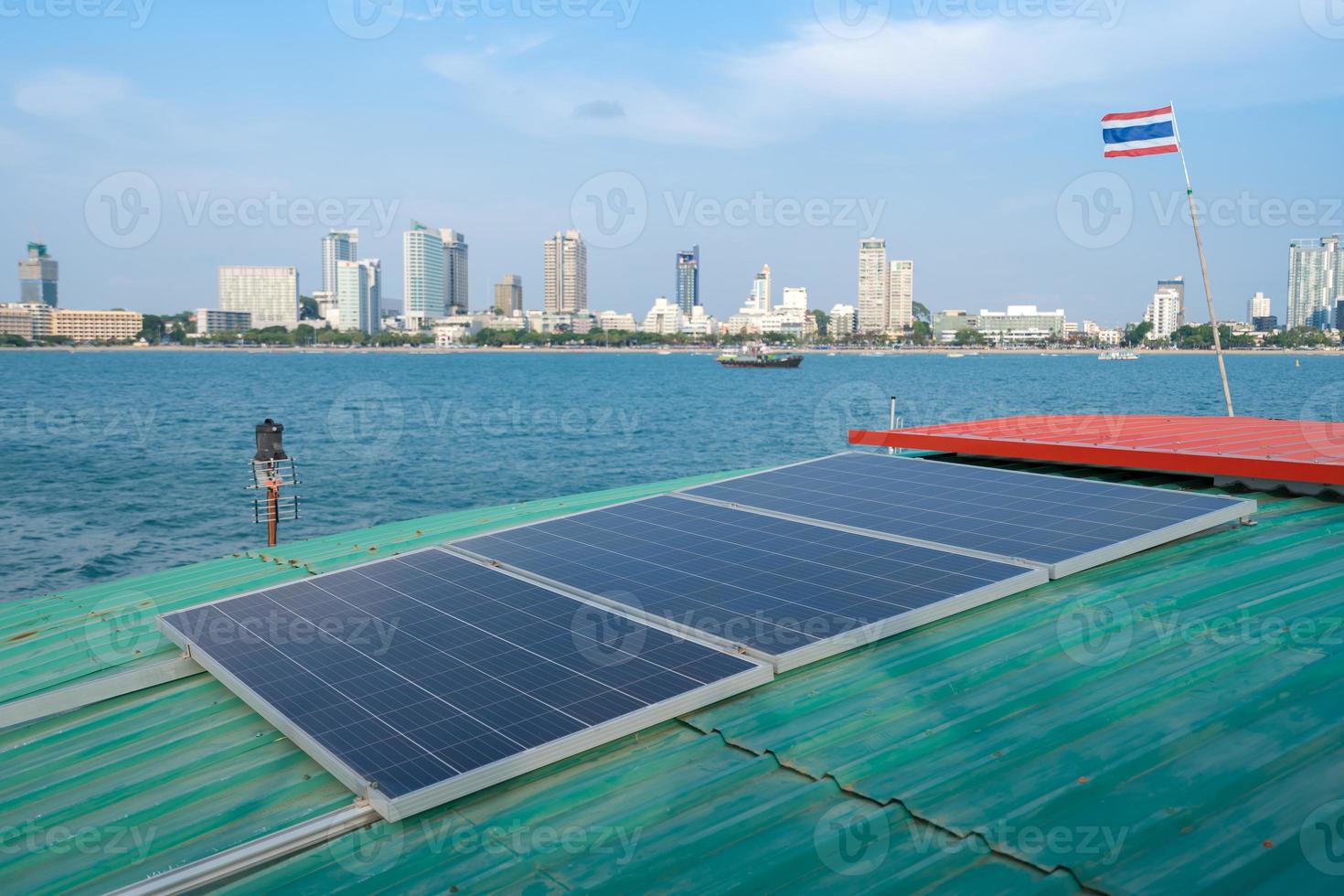 solar panels on roof of floating raft or ship on sea near city coast photo