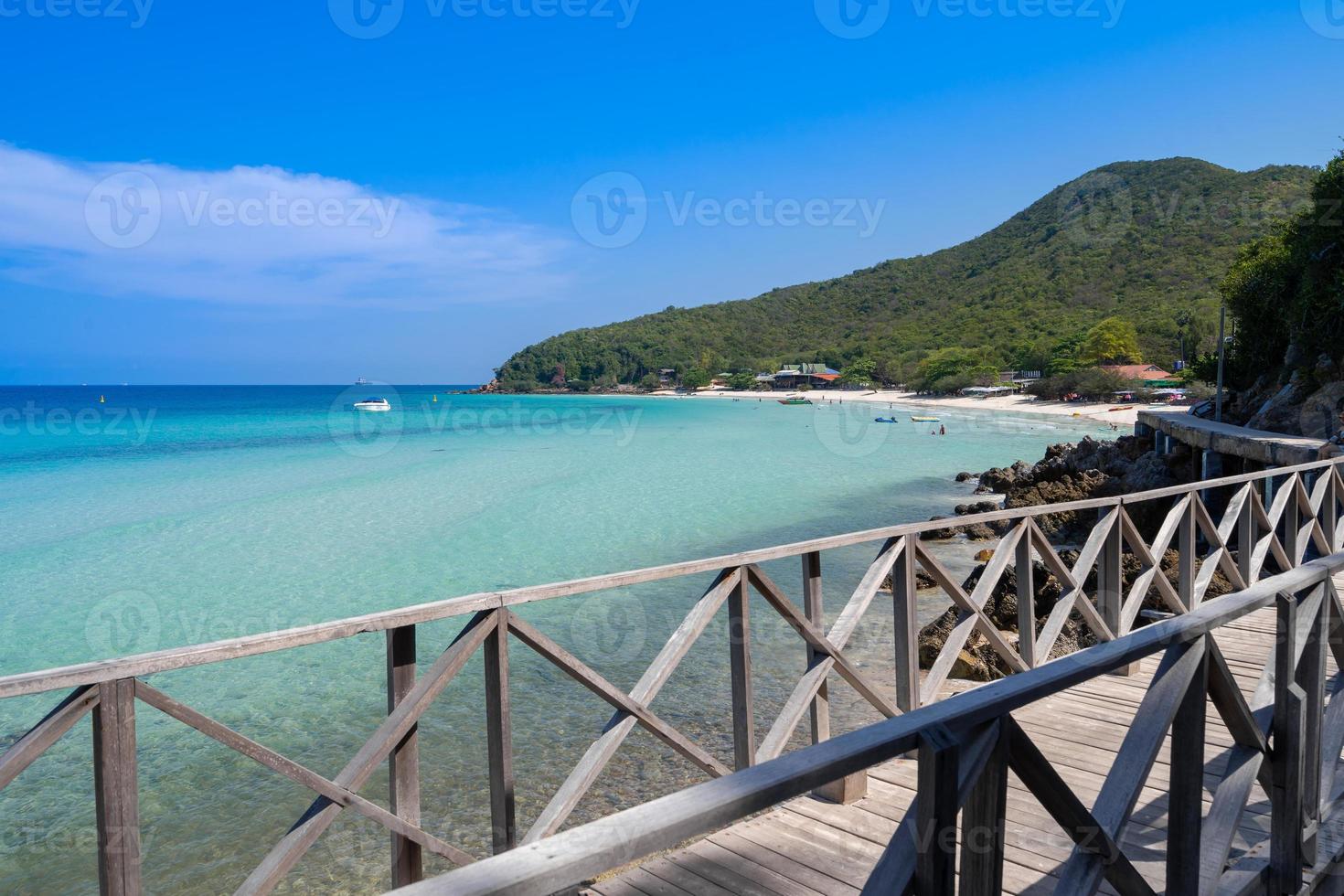 turquoise sea beach with old white wooden bridge walk path on seaside to mountain island photo