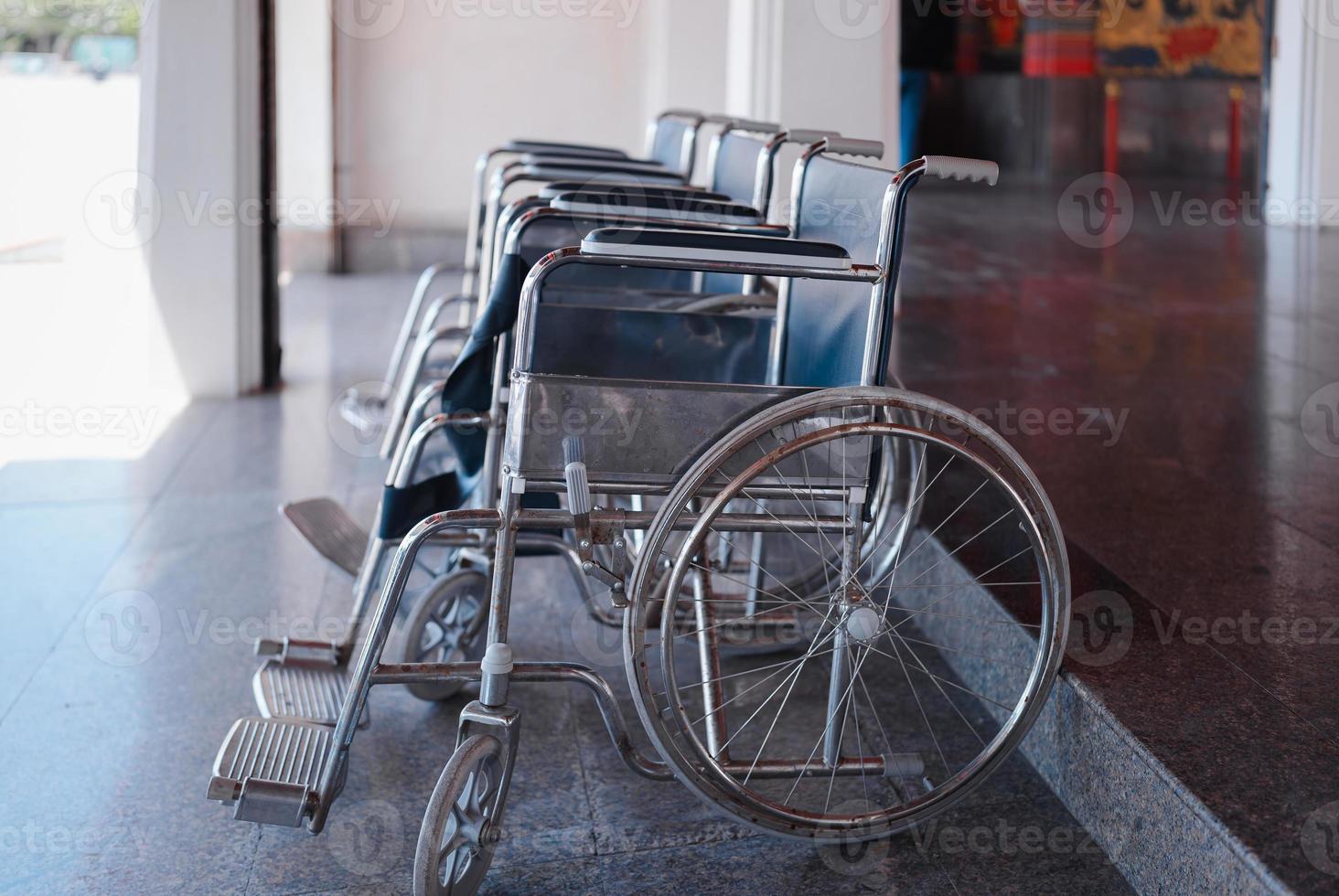 closeup row of empty wheelchairs parking outdoor prepared for for older people and disabled passengers photo