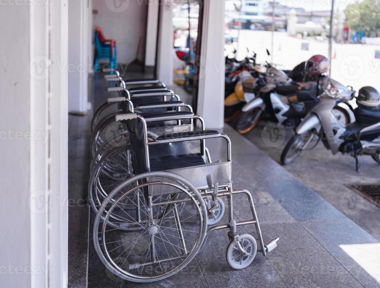 closeup row of empty wheelchairs parking outside prepared for older people and disabled passengers photo