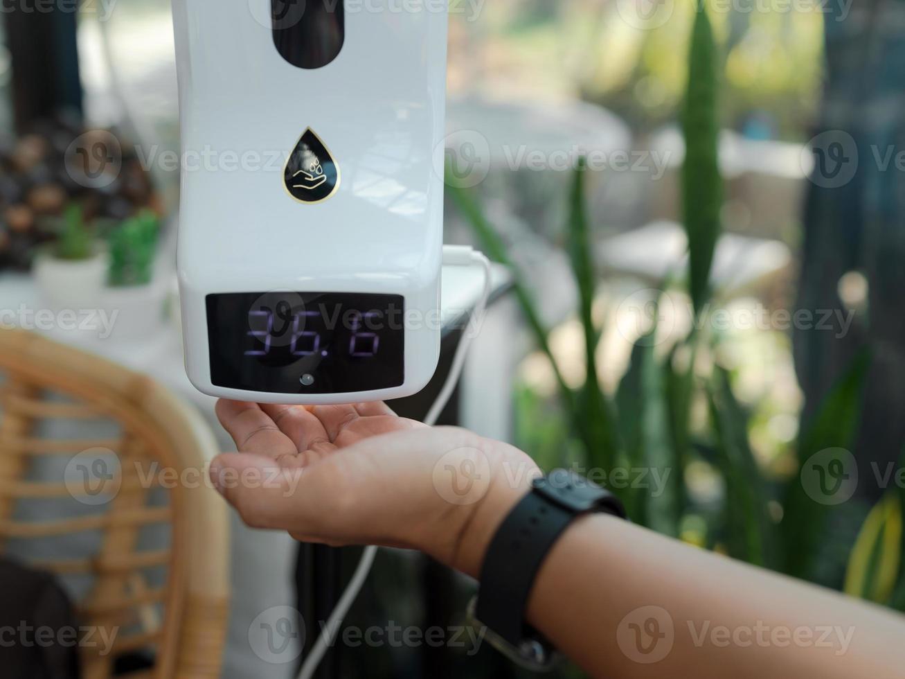 hand under temperature screening digital display normal temp with alcohol gel out photo