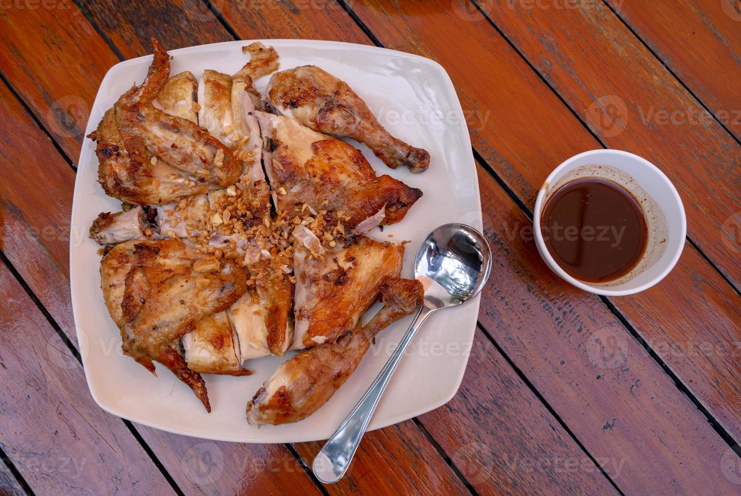top view of roasted chicken seasoning with fried garlic on table photo