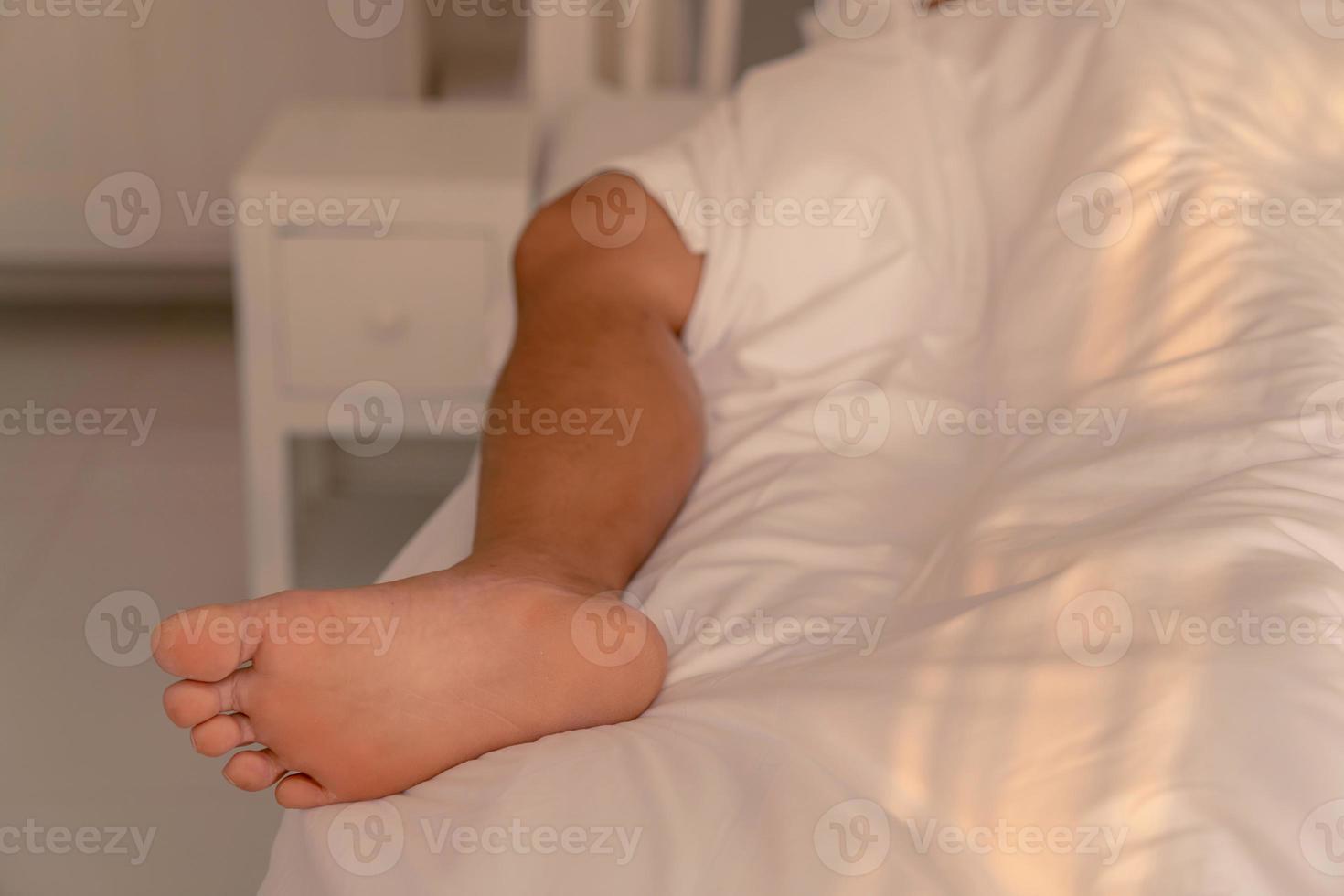 man leg out from blanket in bed photo