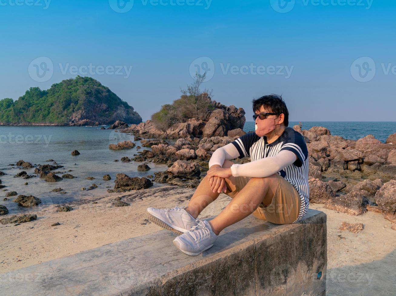 lonely Asian man sit and thinking  at beach island photo