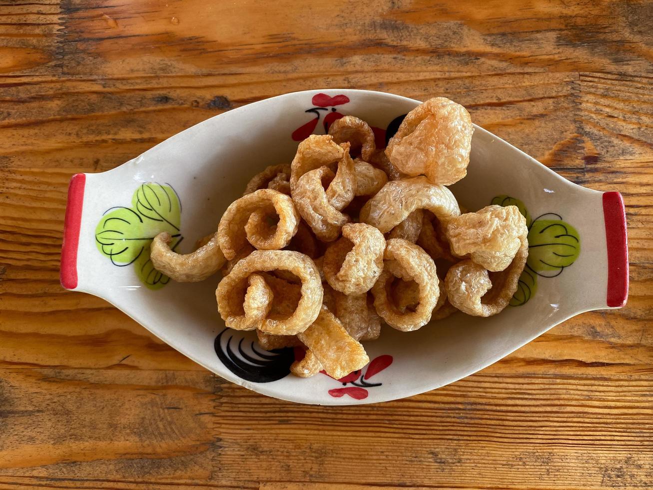 pork rind in a bowl on a wooden table photo