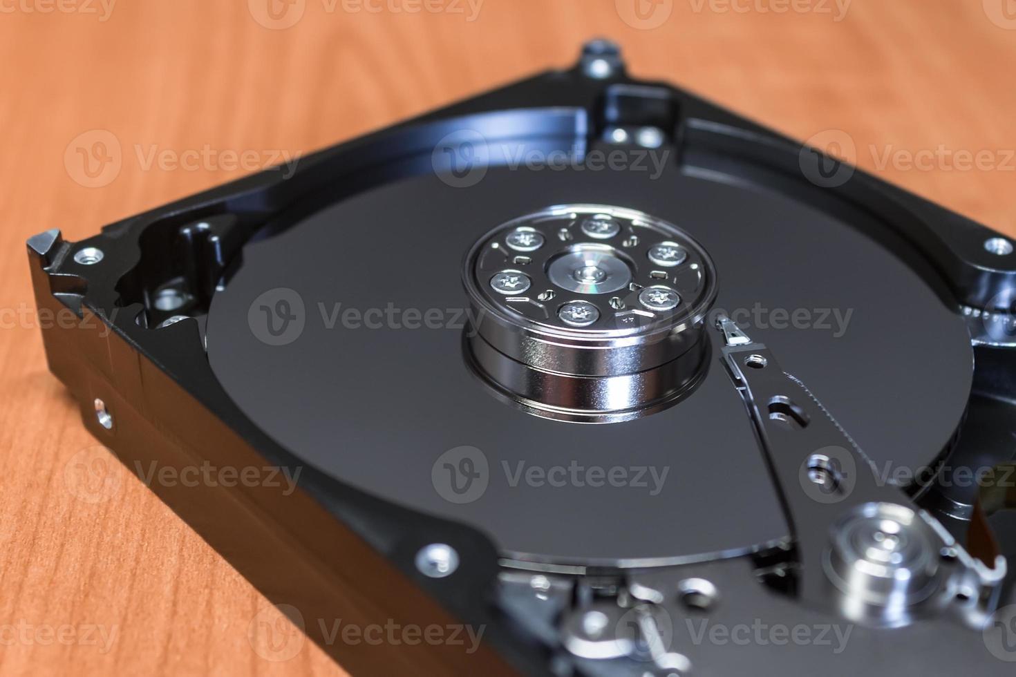 Computer hard drive without a cover, the mirror surface of the disk and parts photo