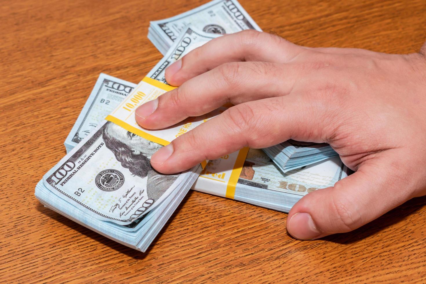 Greedy man grabs a bunch of cash with his hand photo