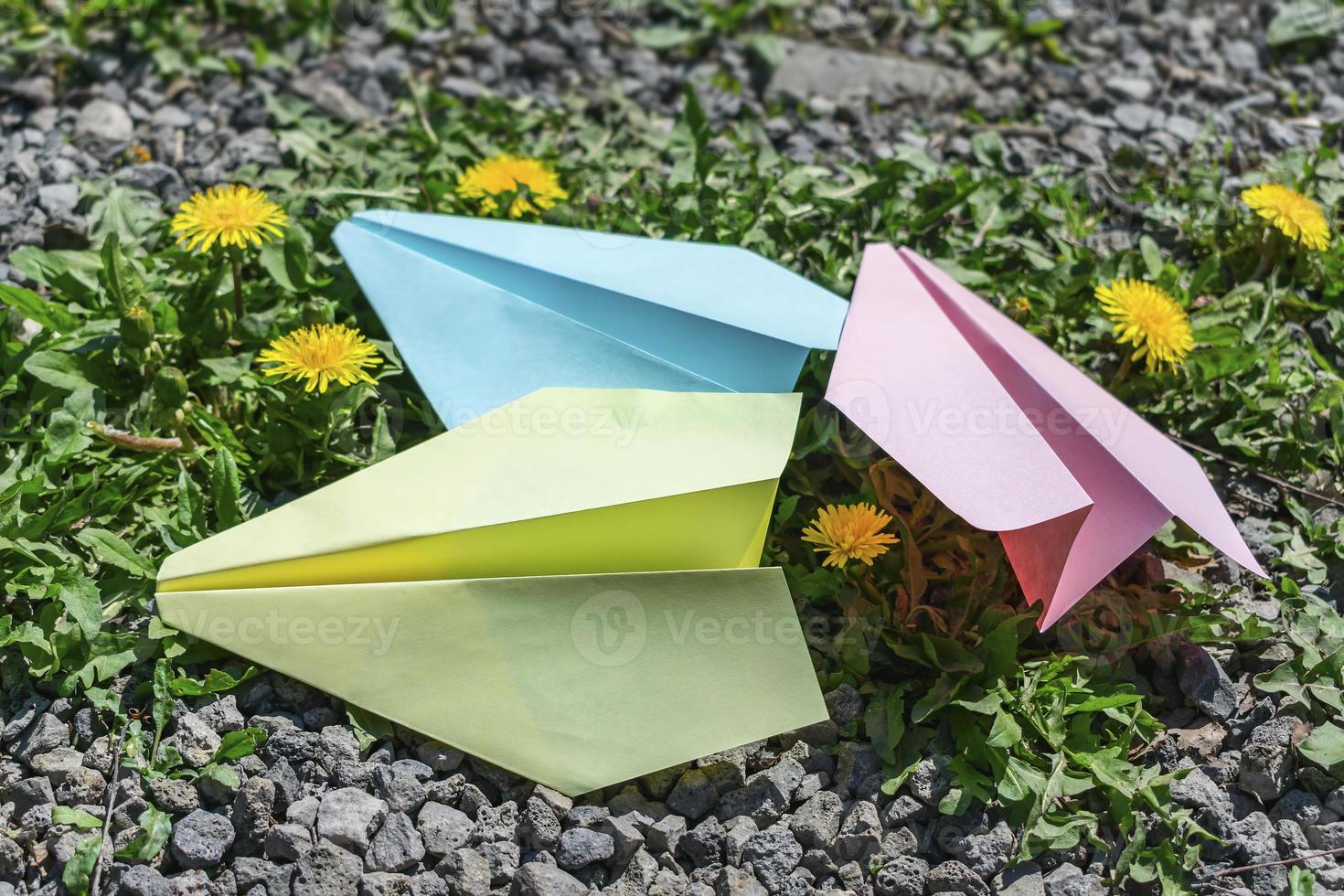 Children's colorful paper airplanes on the grass photo