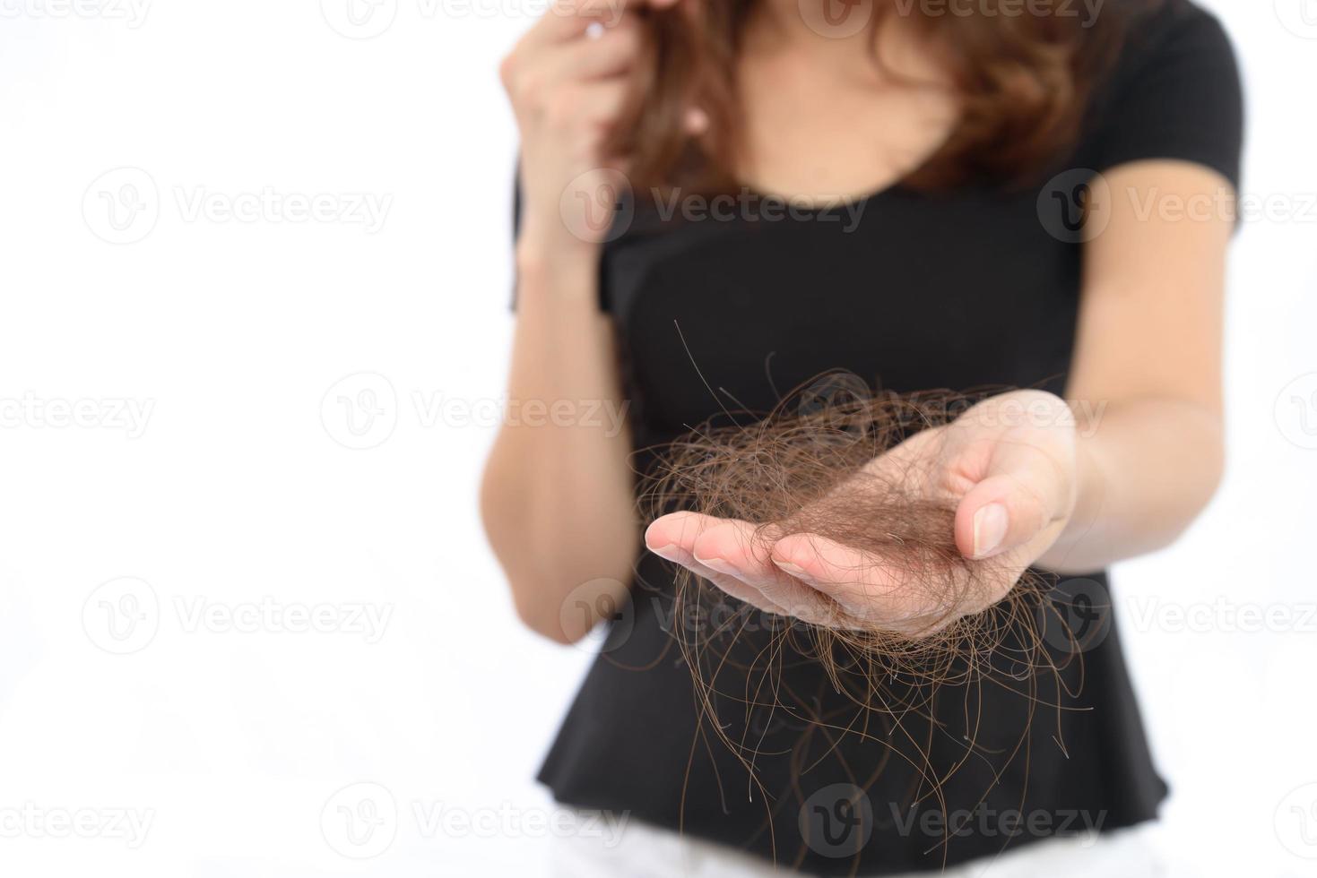 mujeres con problemas de cabello sosteniendo la pérdida de cabello en la mano, isloated sobre fondo blanco foto