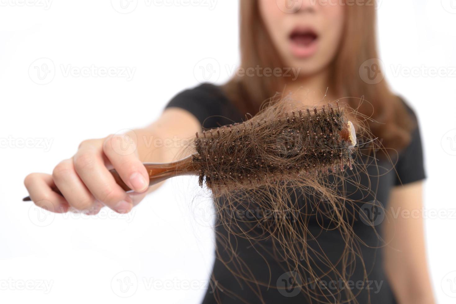 woman losing hair on hairbrush isolated on white photo