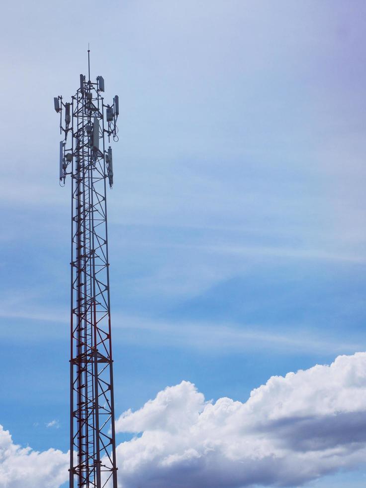 torre telefónica con nubes blancas en el fondo. foto