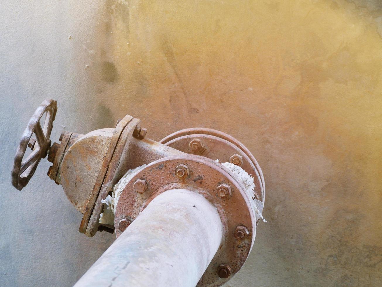 vieja tubería de agua doblada y oxidada y válvula grande. foto