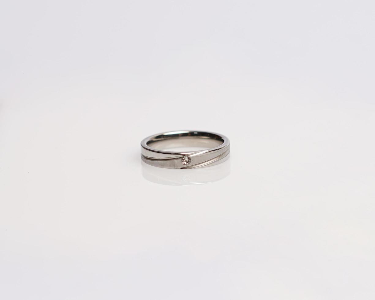 Jewelery ring with diamonds. Wedding rings that have deep meaning and significance. Engagement ring with gemstones. Wedding ring isolated on white background, focus blur. Pair in gold, silver, black. photo