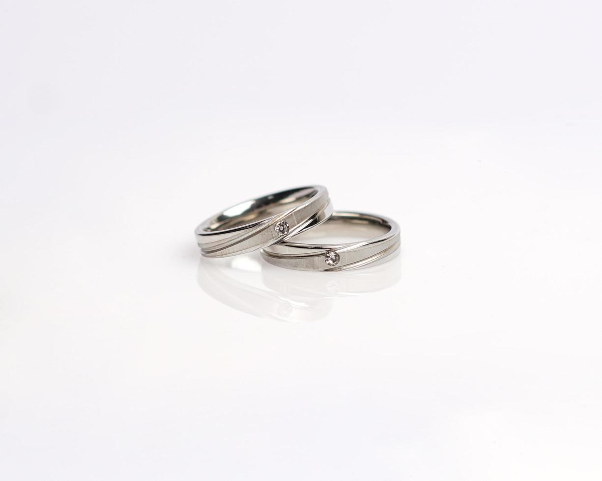 Jewelery ring with diamonds. Wedding rings that have deep meaning and significance. Engagement ring with gemstones. Wedding ring isolated on white background, focus blur. Pair in gold, silver, black. photo