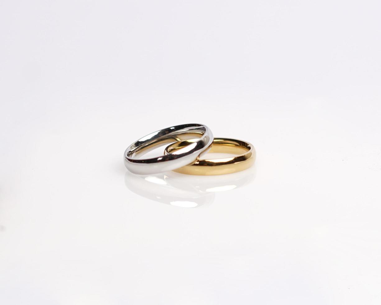 Jewelery ring with diamonds. Wedding rings that have deep meaning and significance. Engagement ring with gemstones. Wedding ring isolated on white background, focus blur. Pair in gold, silver, black. photo