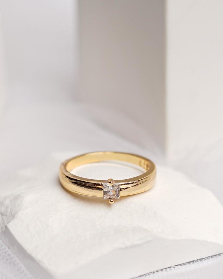 Wedding ring set on white stone. The jewelry ring is ready to be showcased and sold. The wedding ring is a sign of the love of the couple. Pearls and diamonds complete the ring's beauty. focus blur. photo