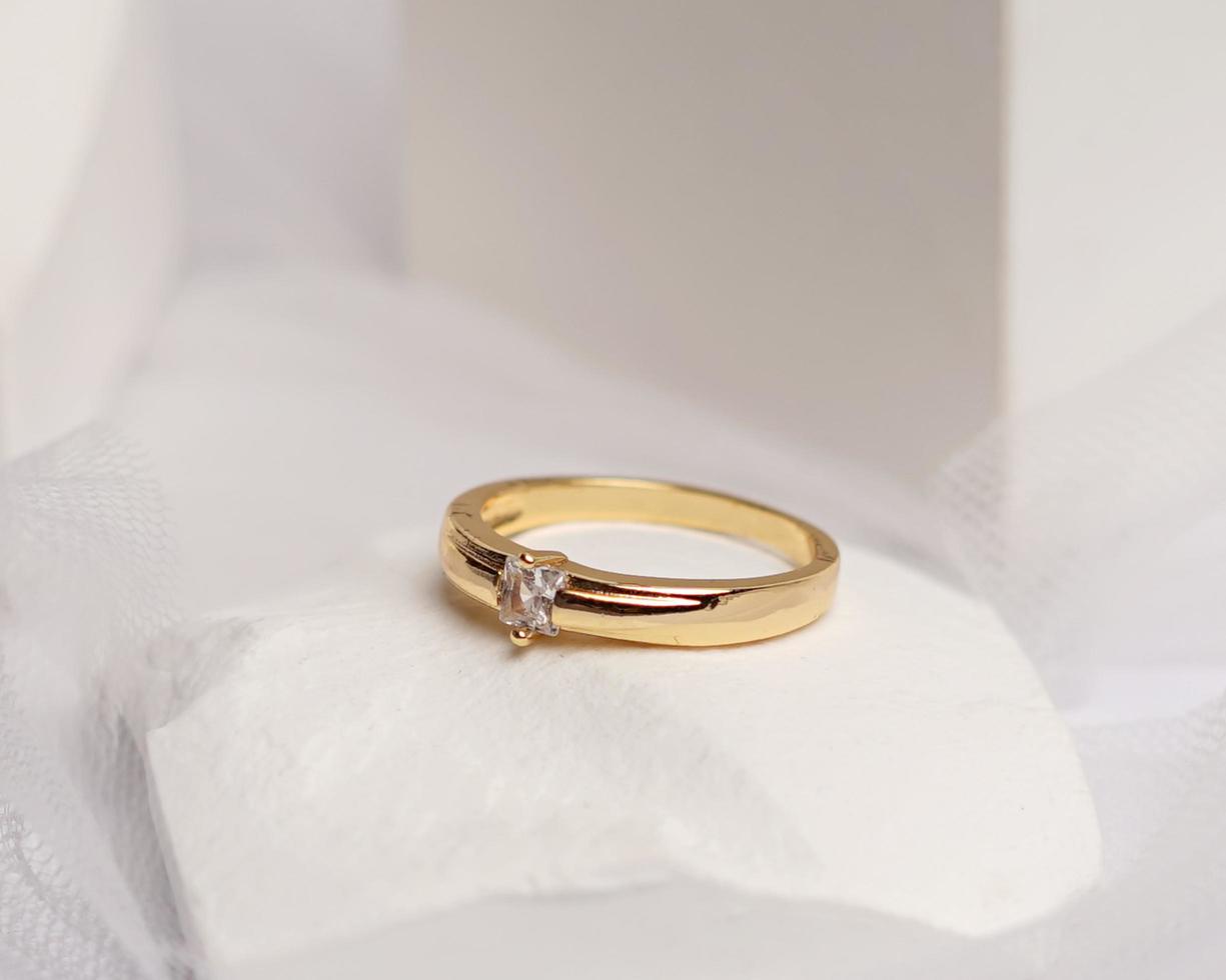 Wedding ring set on white stone. The jewelry ring is ready to be showcased and sold. The wedding ring is a sign of the love of the couple. Pearls and diamonds complete the ring's beauty. focus blur. photo