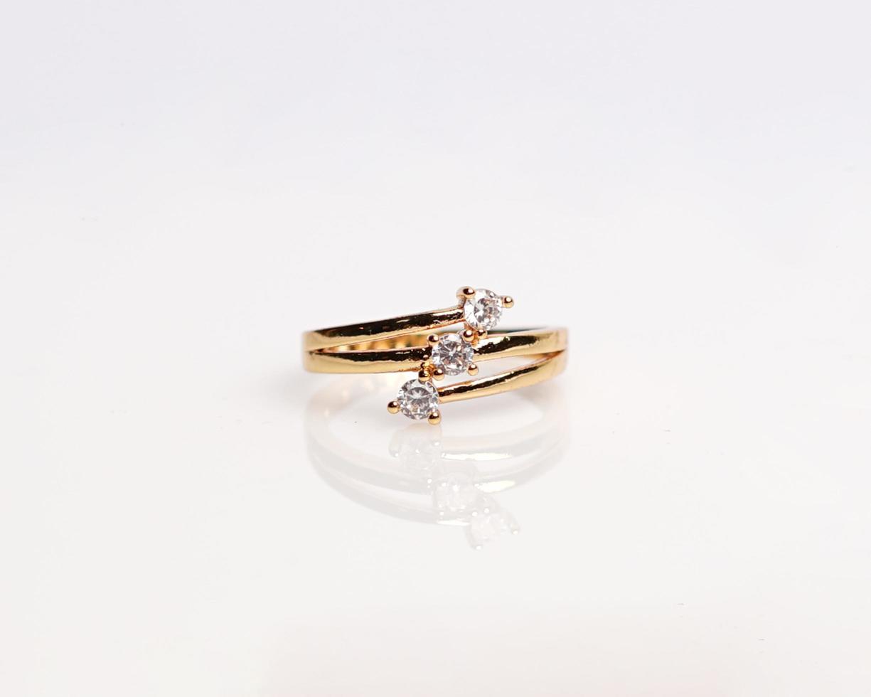 Jewelery ring with diamonds. Wedding rings that have deep meaning and significance. Engagement ring with gemstones. Wedding ring isolated on white background, focus blur. Pair in gold, silver, black. photo