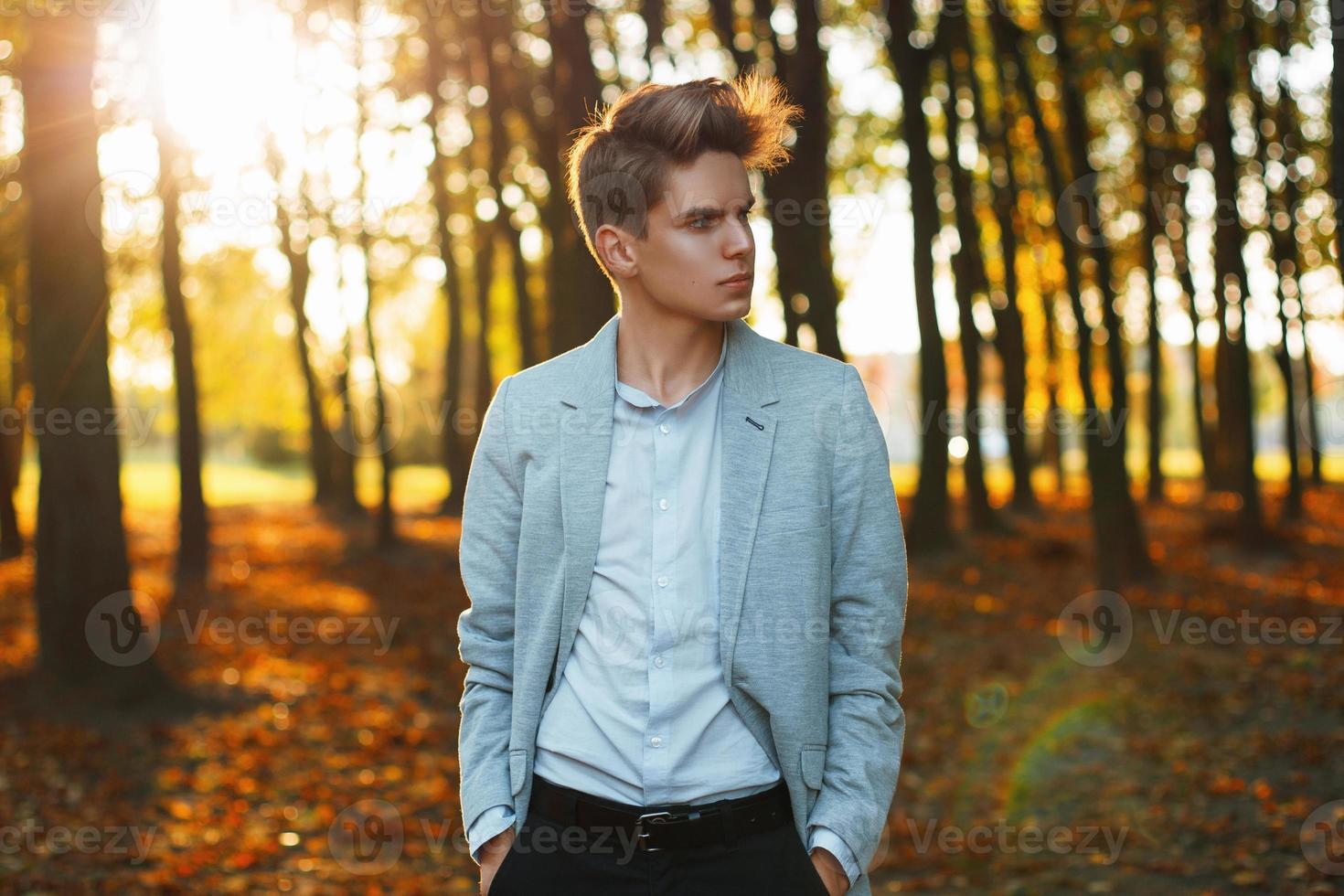 joven empresario urbano profesional caminando en el parque al atardecer. foto