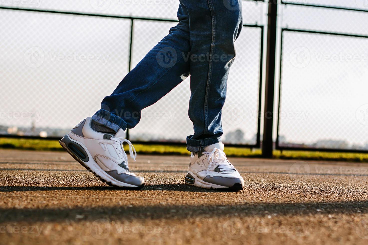 Man with sneakers dancing outside in the stadium at sunset photo