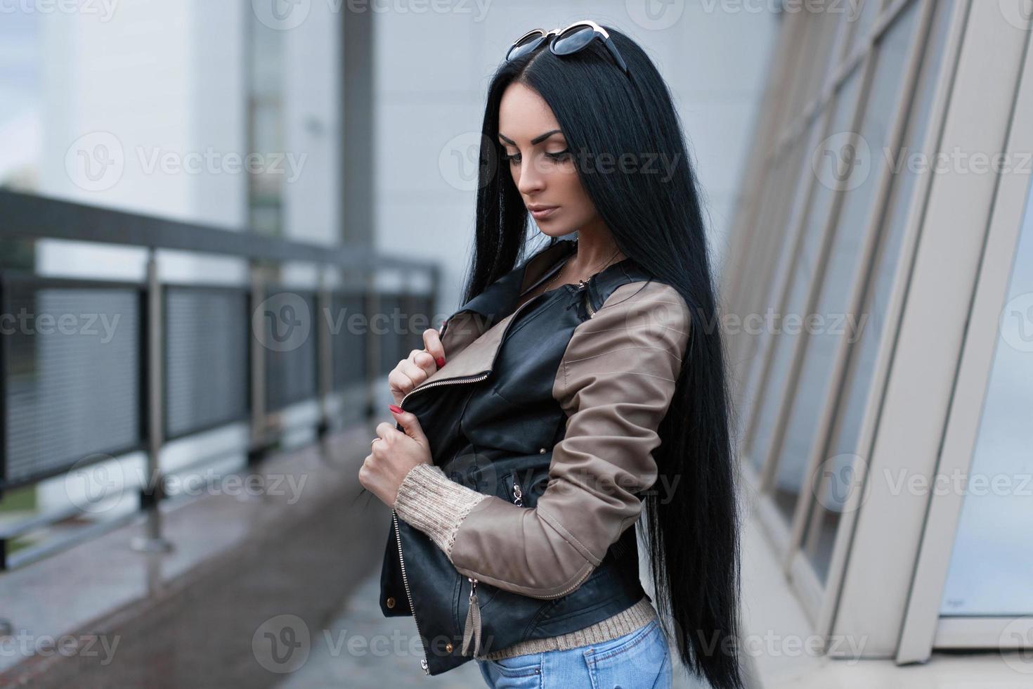 chica con una chaqueta de cuero parada cerca del edificio foto