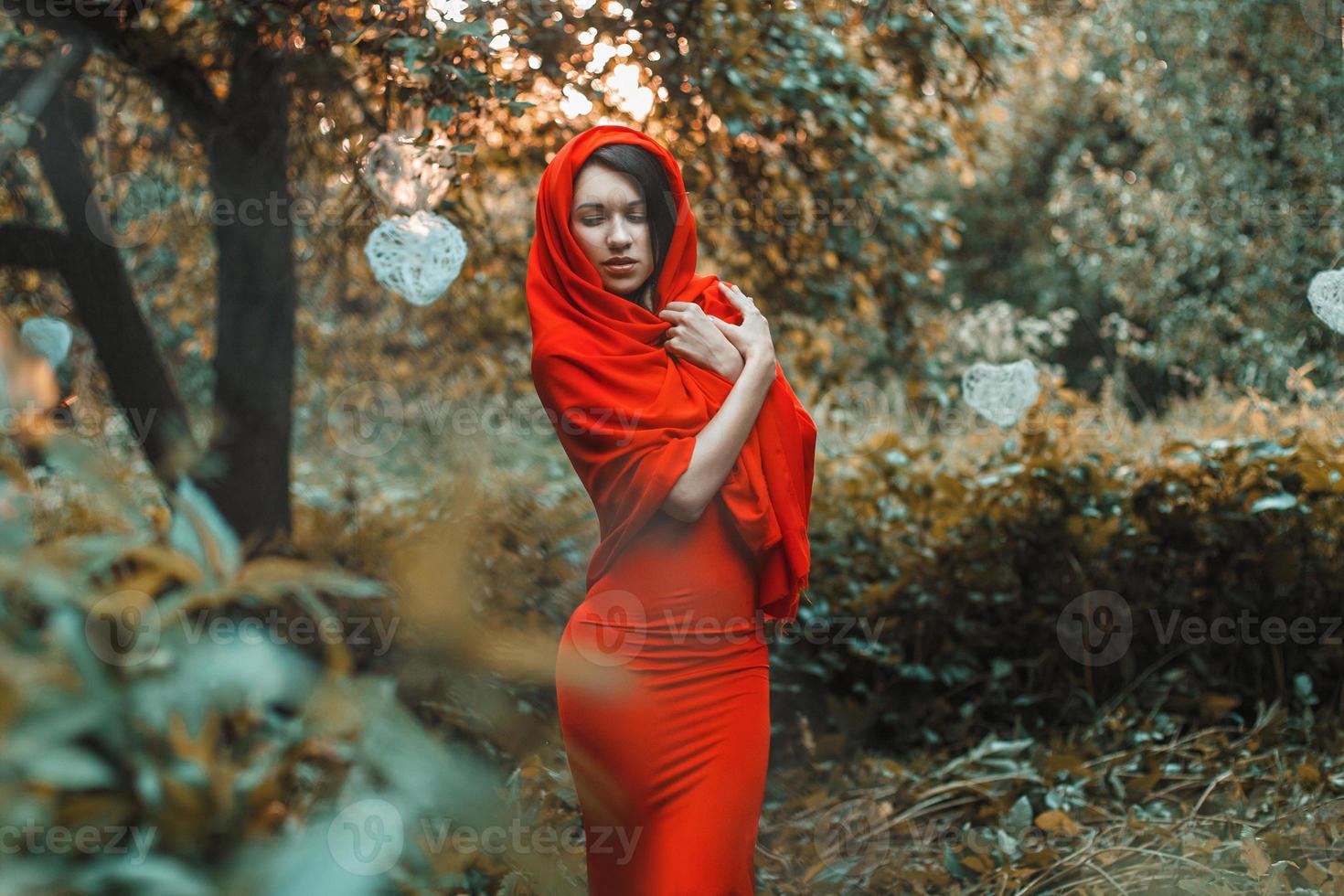 Glorious girl in a red dress in the garden with hearts photo