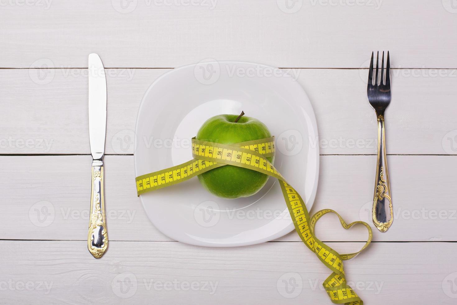 Apple and centimeter on the plate. Sport healthy food. photo