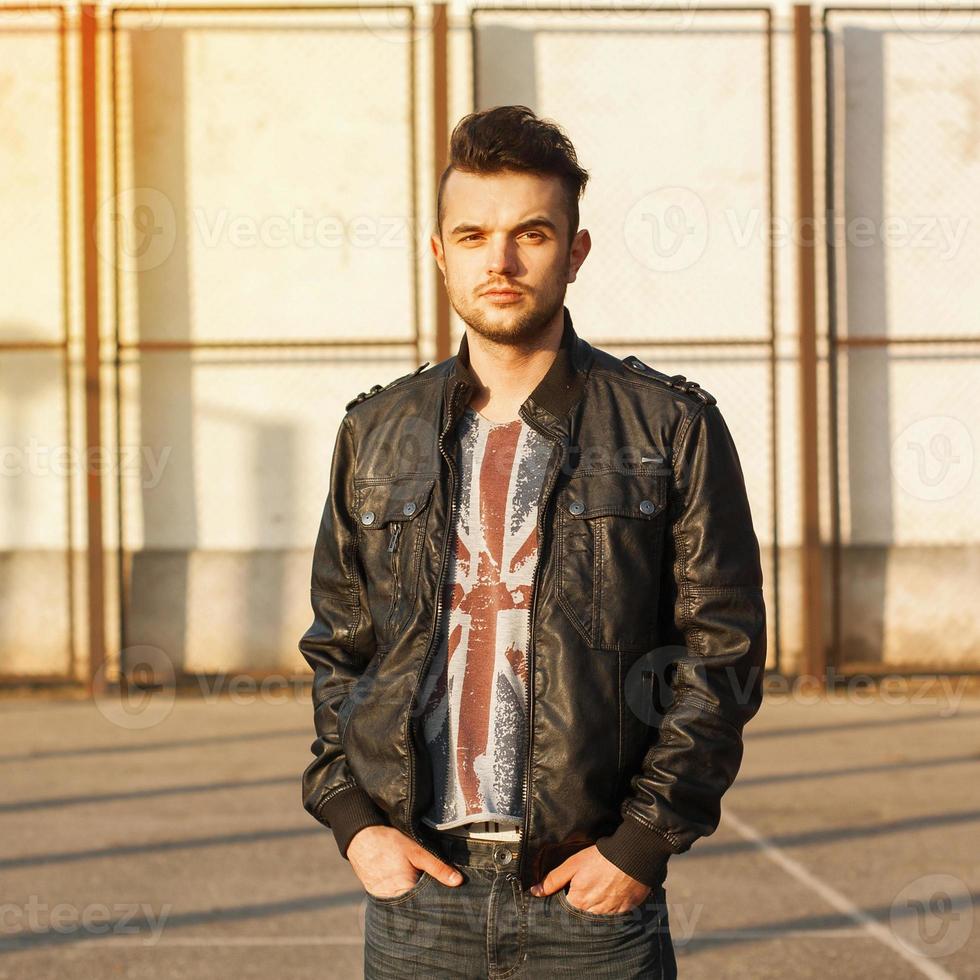 Spring portrait of a young guy in a leather jacket on a sunny day. photo