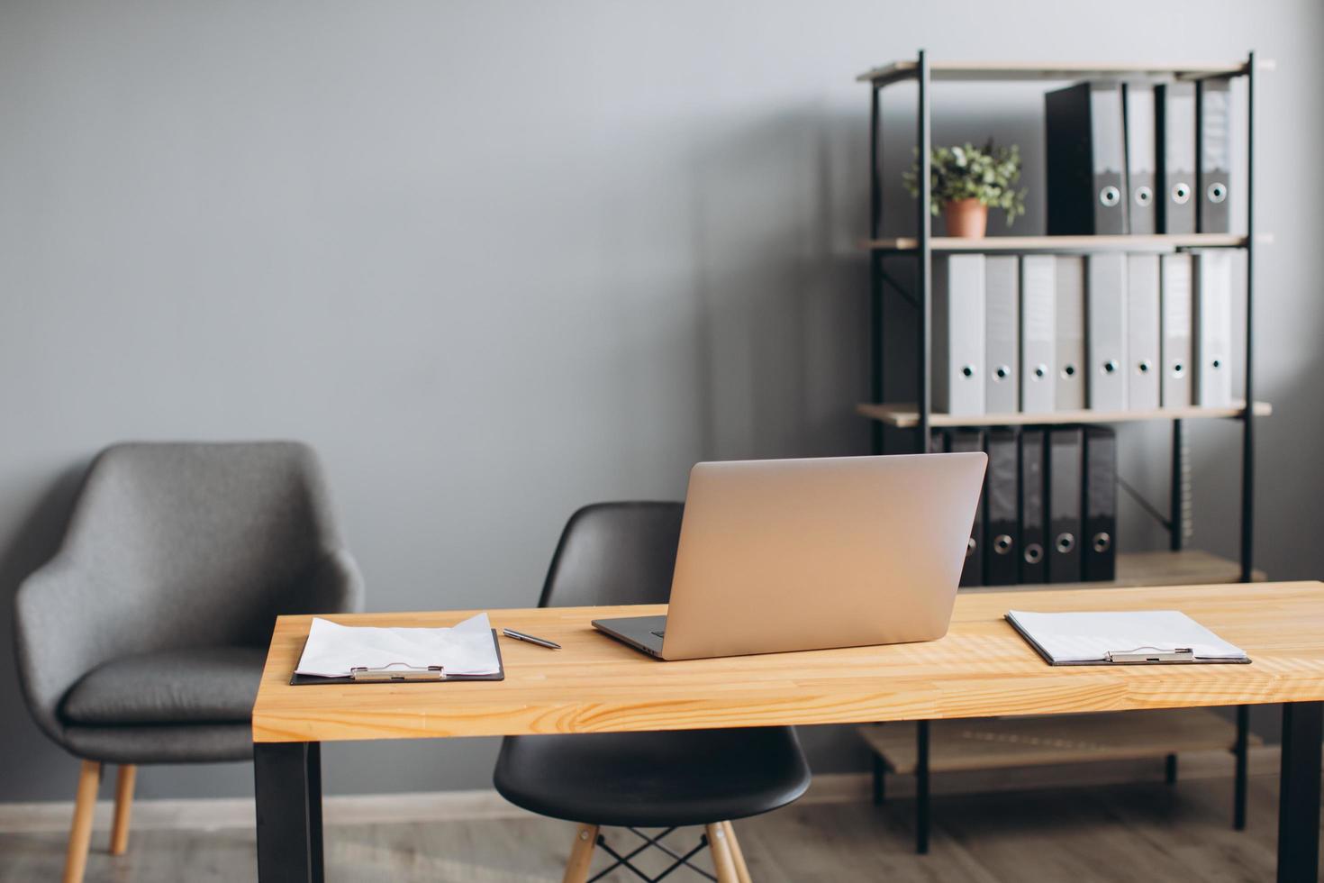 espacio de trabajo elegante con computadora portátil, papelería, teléfono y documentos en la oficina. concepto de escritorio de trabajo. foto