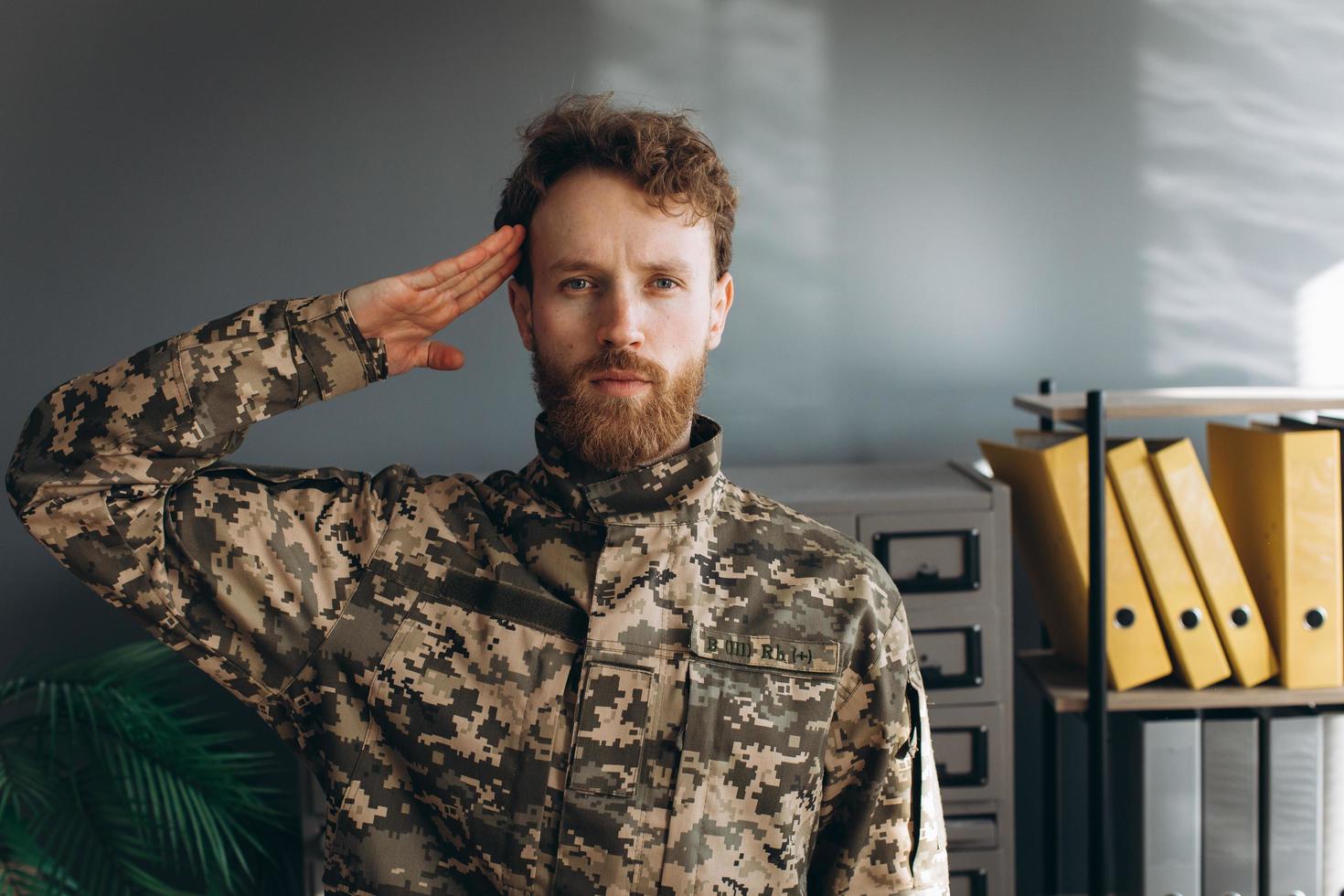 Portrait of a Ukrainian soldier in military uniform paying tribute in the office photo
