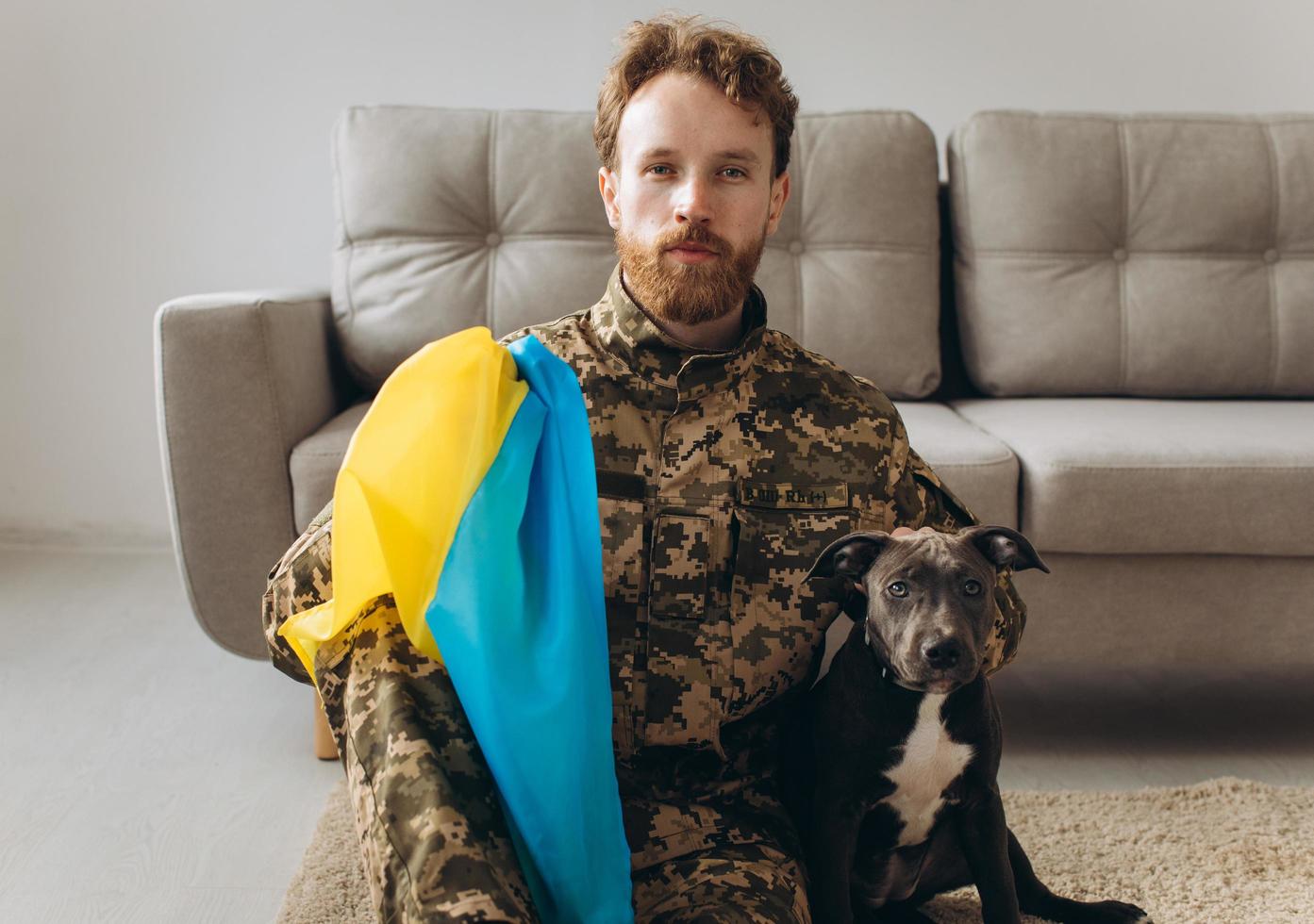 Portrait of a Ukrainian soldier and his faithful friend the Amstaff dog at the office photo