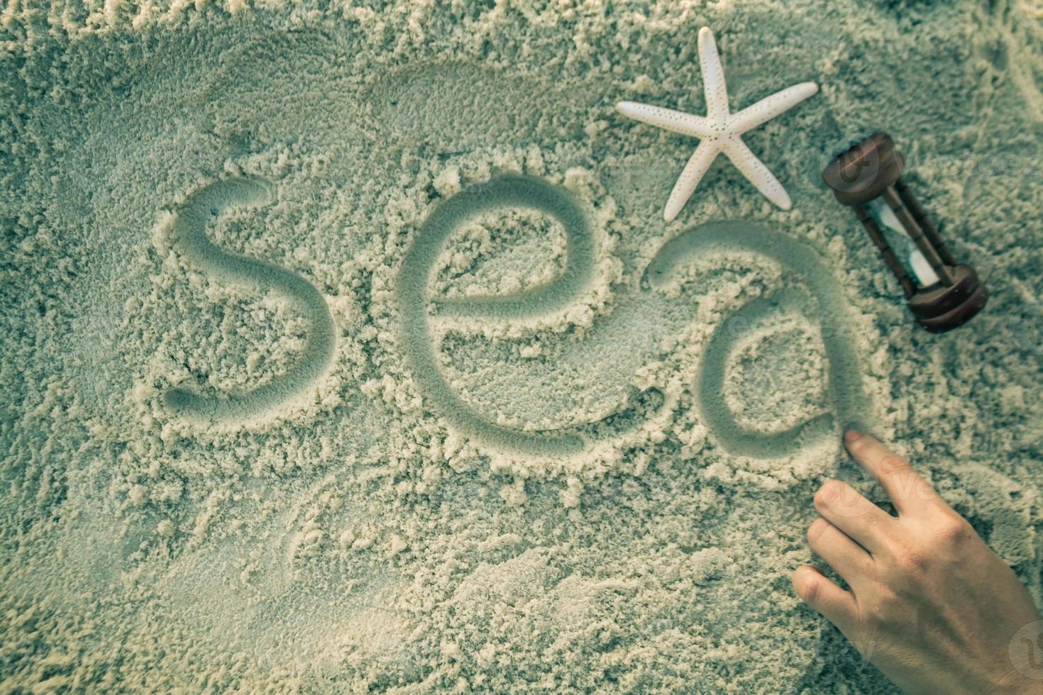 Hand on the white sand. photo