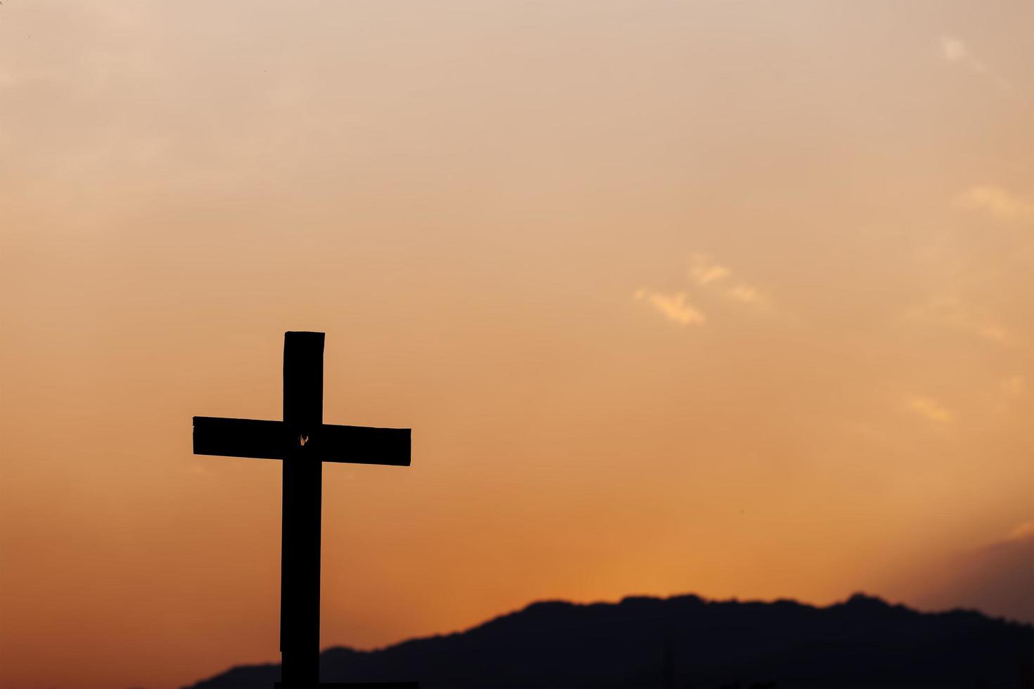 Silhouette of cross on mountain at sunset. concept of religion. photo