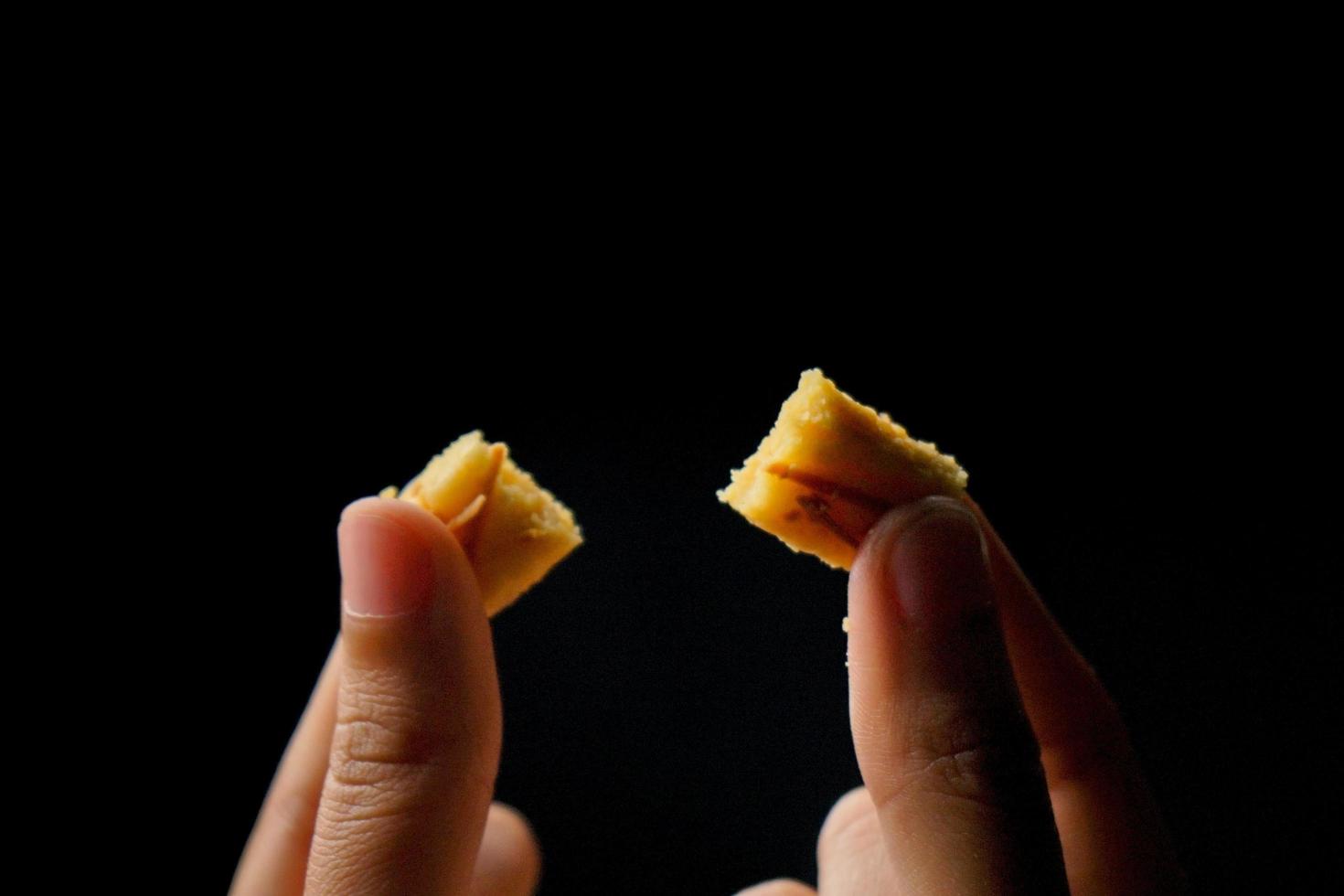 crujientes galletas kaastengels. galletas indonesias de influencia holandesa, típicamente servidas durante hari raya eid fitri. imagen de enfoque selectivo sobre fondo negro foto