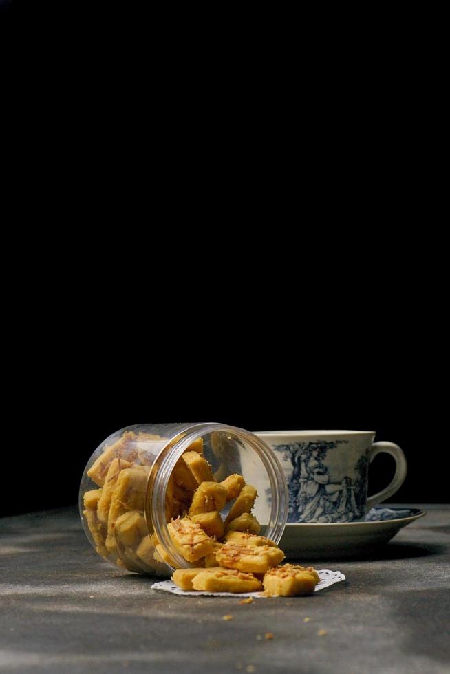 Crunchy kaastengels cookies. Dutch influenced Indonesian cookies, typically served during hari raya Eid Fitri. Selective focus image on black background photo