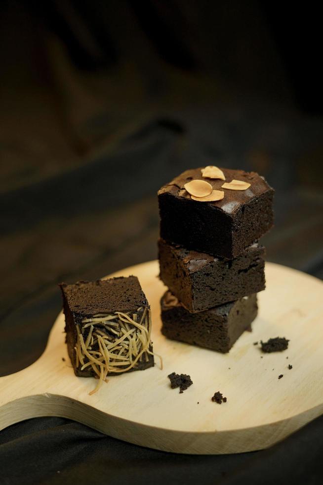 Pieces of fresh brownie on back background. Delicious chocolate pie photo