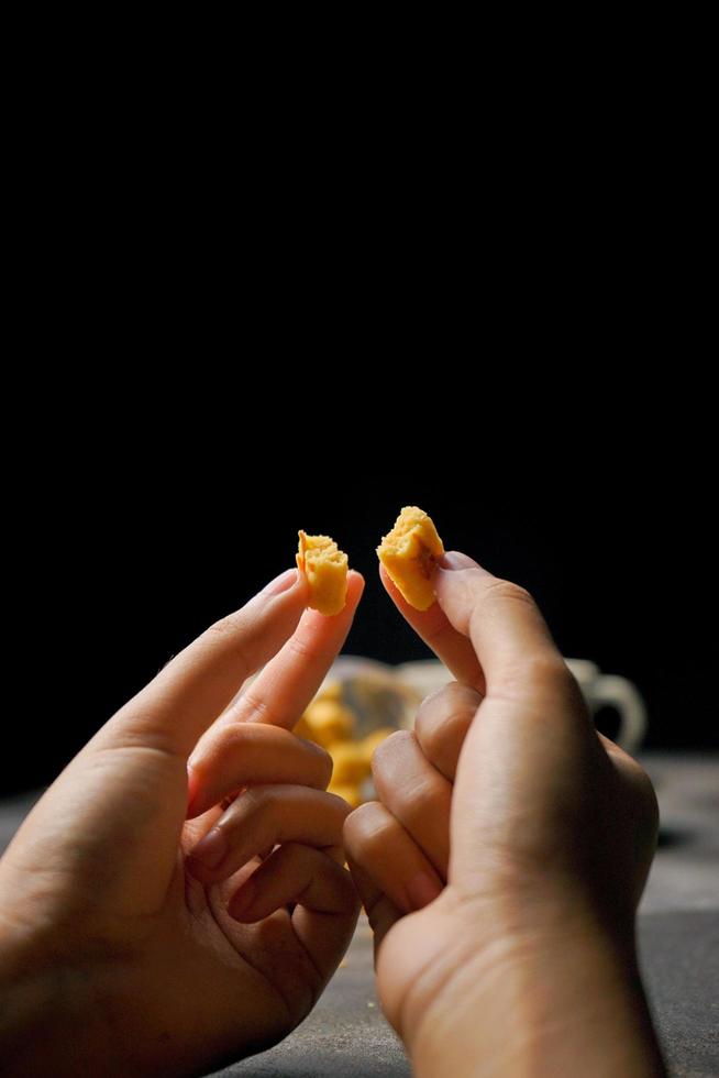 Crunchy kaastengels cookies. Dutch influenced Indonesian cookies, typically served during hari raya Eid Fitri. Selective focus image on black background photo