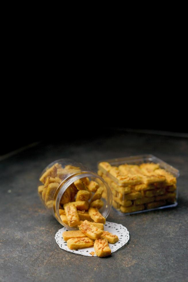 Crunchy kaastengels cookies. Dutch influenced Indonesian cookies, typically served during hari raya Eid Fitri. Selective focus image on black background photo