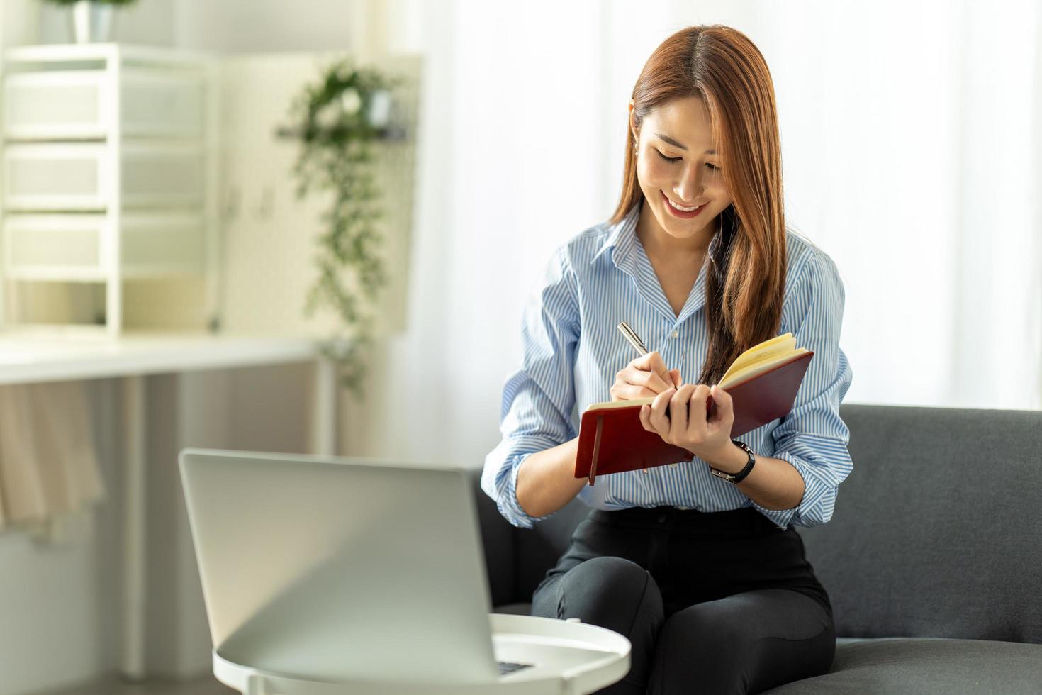 woman using laptop in the sofa with a happy face sitting and smiling with a confident smile. photo