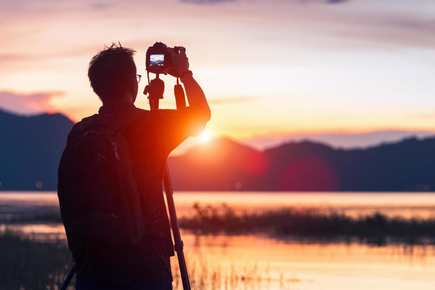 silueta de un fotógrafo que le gusta viajar y fotografiar foto