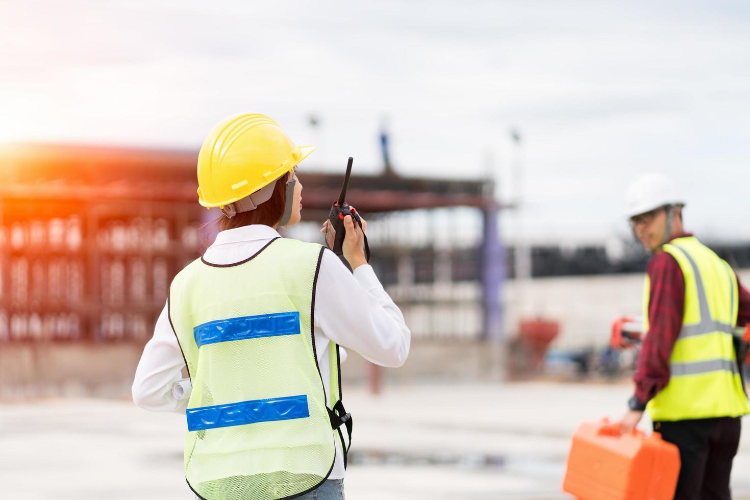 Engineer surveyor using walkie-talkie at construction site photo