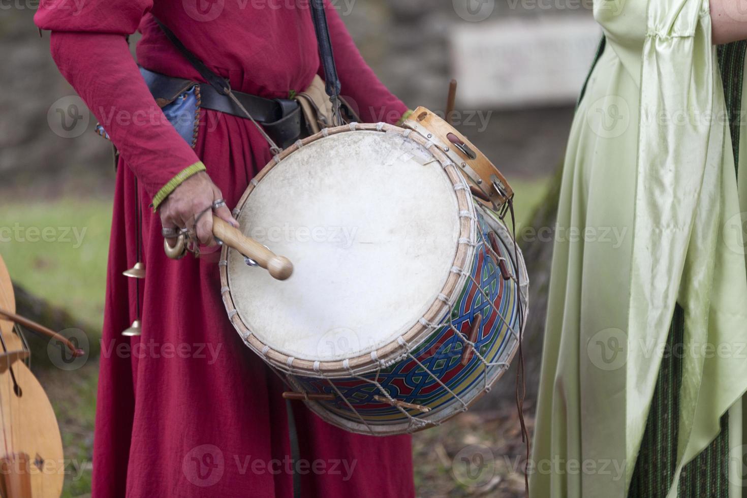 Medieval minstrel playing drum photo