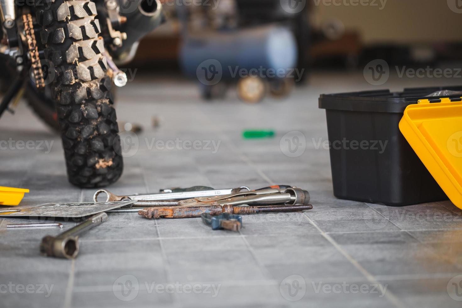 Repairing and maintenance concepts, Worktools on floor for repairing motorcycle in workshop garage photo